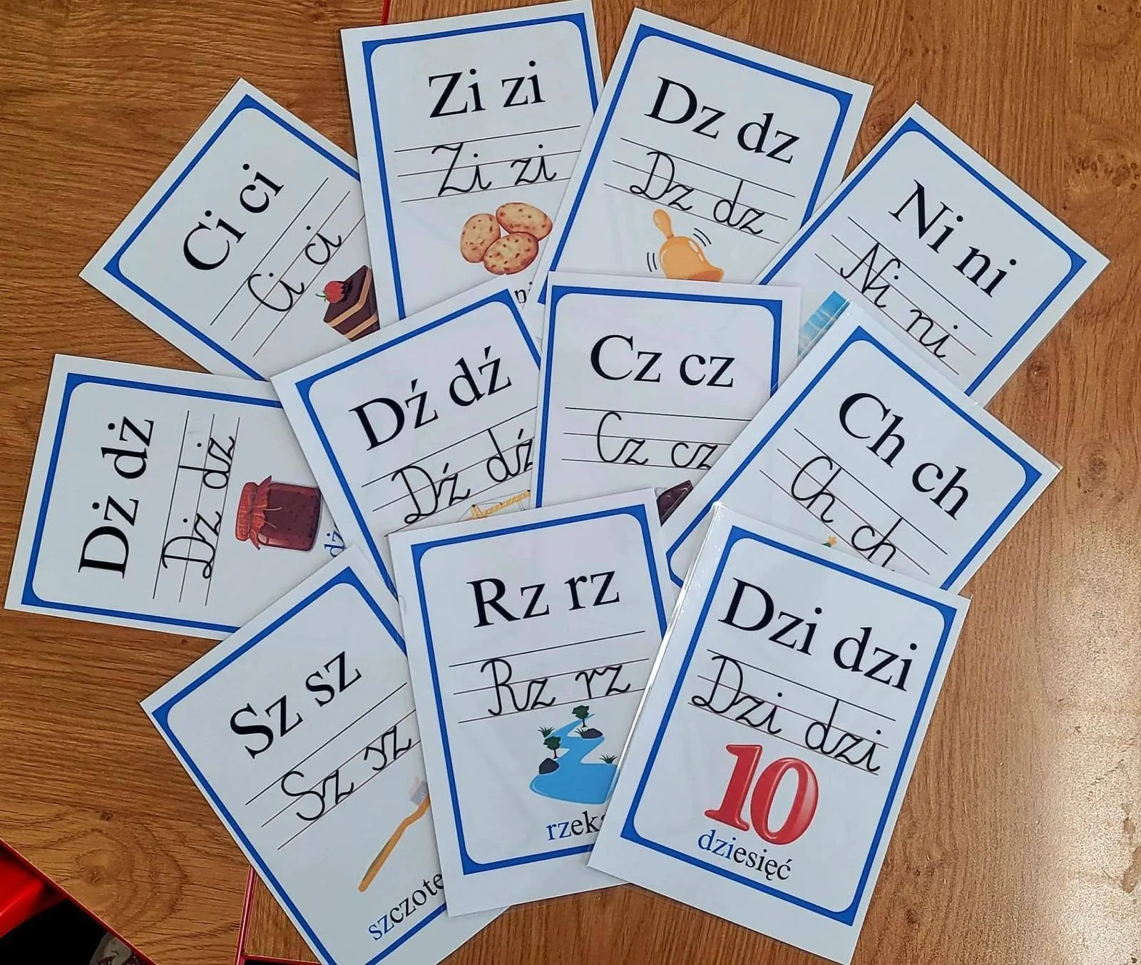 Karty z dwuznakami i zmiękczeniami rozłożone na stole, m.in. „cz”, „sz”, „rz”, „ch” i „dzi”.
