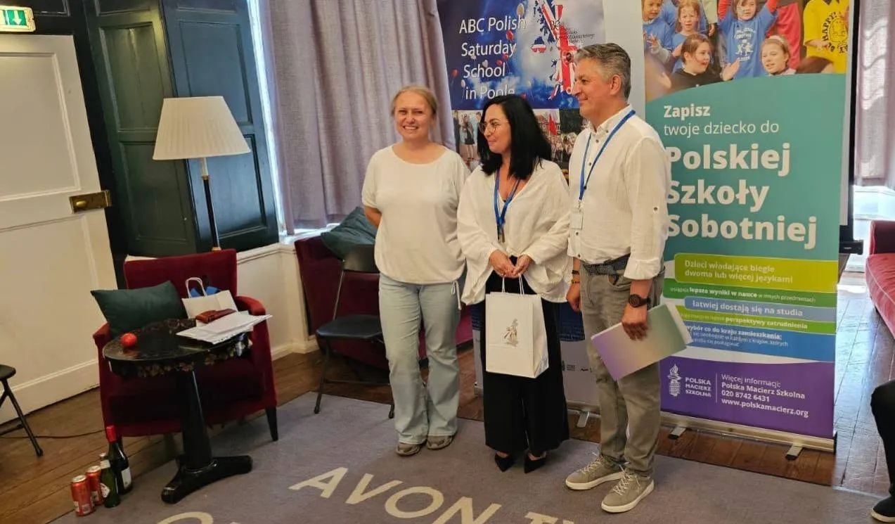 Troje uczestników zjazdu pozuje przy banerach Polskiej Szkoły Sobotniej w sali w Avon Tyrrell.